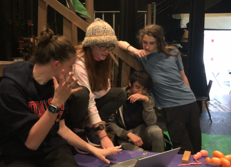 From left to right, Abby Webster ‘23, Hannah Behringer ‘25, Ethan Aniag ‘23, and Campbell Parks ‘25 review the Voodoo script during rehearsal. “We were able to make comments about school through a couple of Greenhills-related sketches like The Day in the Life of Austin Andrews, College Admission Emails, and the demand for the Gryphon Den,” said Behringer.
