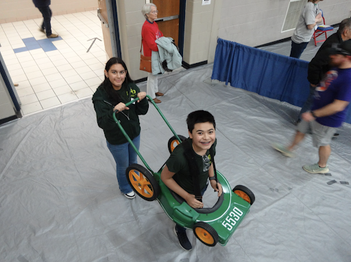 MOWING DOWN THE COMPETITION Kieran Lumeng ‘26 races prepares to race across the stage in “the lawnmowers” costume along with Ivy Belen ‘26 during competition
