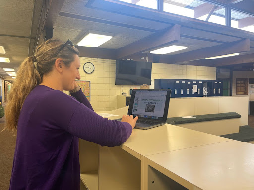 ENTERING A DIGITAL ERA  Eighth Grade Team Leader Katherine Vane works on getting her slide deck ready to upload on the screens for the next day, she said, “If students weren't listening [during grade meeting] or they didn't catch all the information, they can look up on the screen. They're hearing it and seeing it, which is never a bad thing.” 
